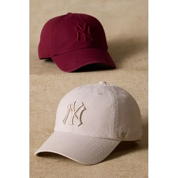 Two embroidered NY baseball caps by '47, in burgundy and light beige.