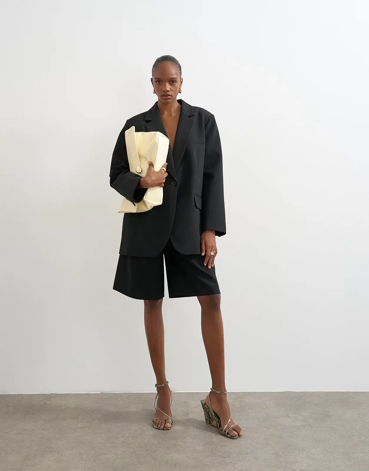 Model wearing black Topshop Bermuda shorts with a black blazer.