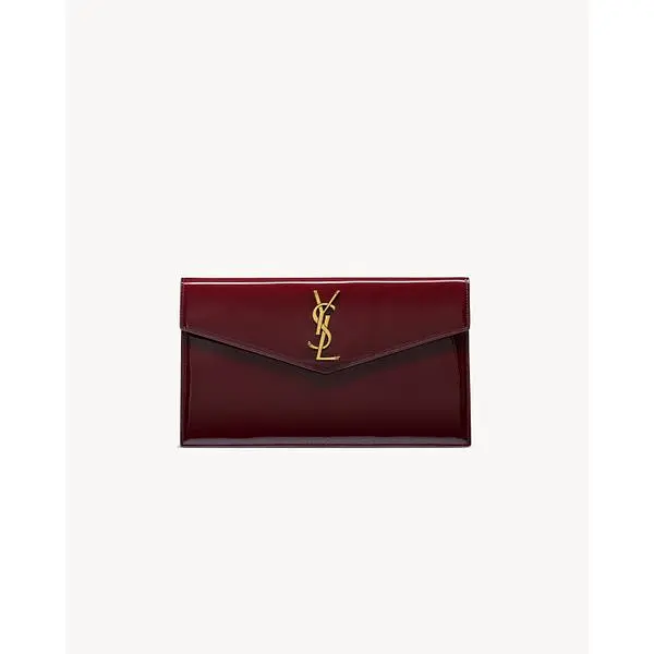 Burgundy Saint Laurent Uptown envelope pouch with a gold-tone YSL monogram.