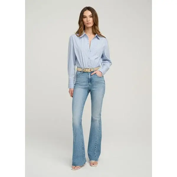 Modella con jeans blu a zampa e camicia azzurra.